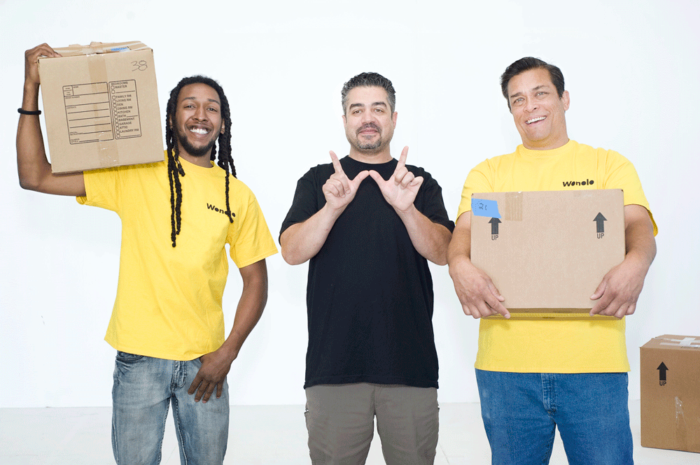 Three retail workers in Wonolo shirts are shown standing and holding brown boxes.